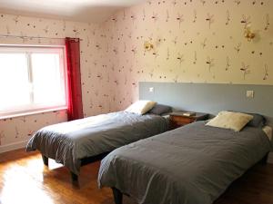 a bedroom with two beds and a window at Gîte chaleureux avec poêle à bois et jardin à Lavoine - FR-1-489-332 in Lavoine
