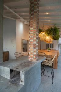 a room with a table and chairs and a brick pillar at Kasa Venecia in Calarcá