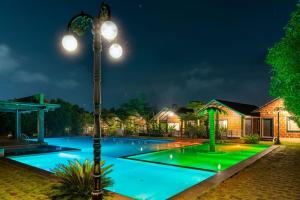 - une piscine avec un pôle lumineux la nuit dans l'établissement Dandeli Resorts Booking, à Dandeli