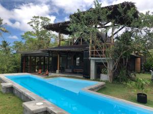 a house with a swimming pool in front of it at Private villa with pool, sunset view, solar powered in Siquijor
