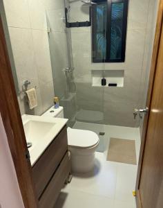 a bathroom with a shower and a toilet and a sink at Cocotal 2beds apartament Golf Course Melia Beach PC RD in Punta Cana