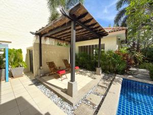 a patio with a pergola next to a swimming pool at Villa 4 BD Nai Harn Beach by Mill in Ban Saiyuan (1)