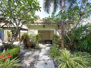 a garden with trees and plants in front of a house at Villa 4 BD Nai Harn Beach by Mill in Ban Saiyuan (1) +36 photos