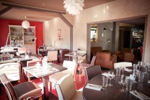 a restaurant with tables and chairs in a room at Hôtel Restaurant Logis Coté Lac in Savenay