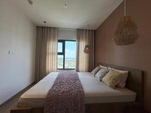 een slaapkamer met een groot bed met een raam bij The Urban Origami S703 in Long Bình