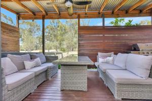 a patio with wicker couches and a table at Stay at Shiraz in Belford