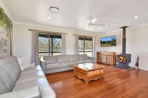 a living room with a couch and a fireplace at Stay at Shiraz in Pokolbin