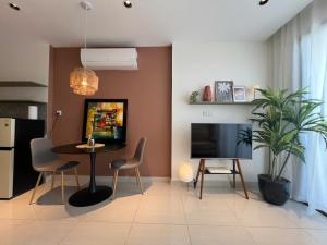 een woonkamer met een televisie en een tafel en stoelen bij The Urban Origami S703 in Long Bình