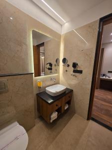 a bathroom with a sink and a toilet and a mirror at Hotel Rivera Palace in Varanasi