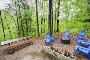 un groupe de chaises bleues et une table de pique-nique et un foyer dans l'établissement Hot Tub & WiFi - Hidden Chalet Red River Gorge KY, à Campton