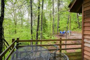 - une terrasse couverte avec une table et des chaises sur une clôture dans l'établissement Hot Tub & WiFi - Hidden Chalet Red River Gorge KY, à Campton