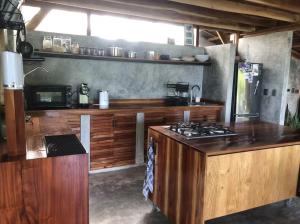 a kitchen with wooden cabinets and a stove top oven at Private villa with pool, sunset view, solar powered in Siquijor