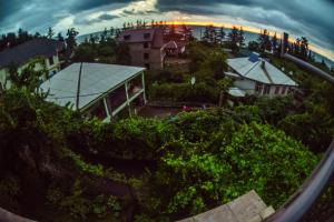 una vista aérea de un edificio con una puesta de sol en el fondo en Batumi Homestay at Tamar Mephe Avenue en Makhinjauri