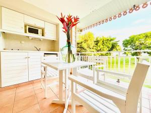 a kitchen with a table and a vase of flowers at DESIRADE 18 sainte luce in Sainte-Luce