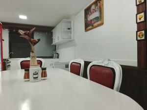 a kitchen with a table with chairs and a vase on it at Aracari Inn Mindo in Mindo