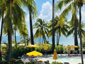 a pool with chairs and umbrellas and the ocean at DESIRADE 18 sainte luce in Sainte-Luce