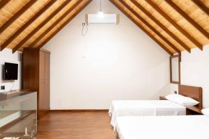 a bedroom with two beds and a tv at Sakun villa in Mirissa