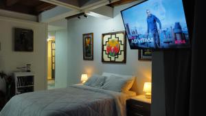 a bedroom with a bed and a flat screen tv at Aracari Inn Mindo in Mindo
