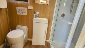 a small bathroom with a toilet and a shower at Wilderness Whisper By Tiny Away in Agnes Water +9 photos