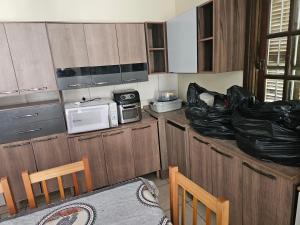 a small kitchen with wooden cabinets and a microwave at Casa completa proximo a FURG in Rio Grande