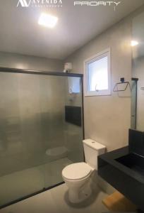 ein Badezimmer mit Toilette und Dusche und einem Fenster in der Unterkunft Priority Praia Grande in Praia Grande