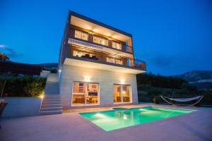 a building with a swimming pool in front of a house at Villa Diosa de la Aurora in Klis