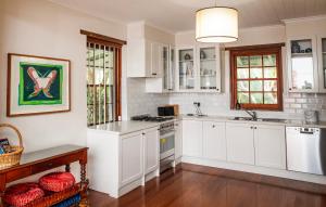une cuisine blanche avec des armoires blanches et une table dans l'établissement Old Duninald House - Historic Farmhouse Experience, à Paterson 8 autres photos