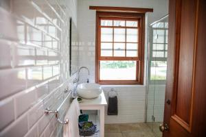 une salle de bain avec un lavabo et une fenêtre dans l'établissement Old Duninald House - Historic Farmhouse Experience, à Paterson