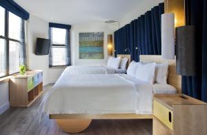 a large bedroom with two beds and a tv at Arthouse Hotel in New York