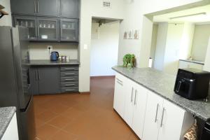 a kitchen with white cabinets and a black refrigerator at Sleep-A-Lot in Piet Retief