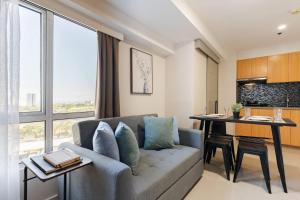 un salon avec un canapé et une table dans l'établissement Family Loft Unit Hotel in BGC The Fort High Street, à Manille