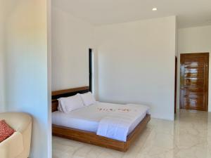 a bedroom with a bed and a couch at Wisuthida Villa in Wang Saphung