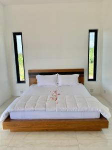 a bedroom with a large bed with two windows at Wisuthida Villa in Wang Saphung +12 photos