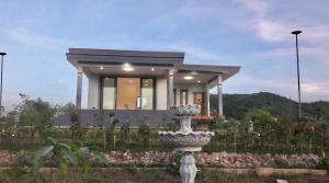 a house with a statue in front of it at Wisuthida Villa in Wang Saphung