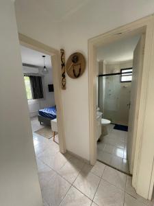 a room with a bathroom with a toilet and a mirror at Toninhas - Condomínio Wembley Tênis F201 in Ubatuba