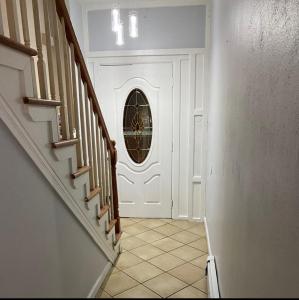 een hal met een witte deur met een rond raam bij Private bathroom inside Master bedroom! in Paterson