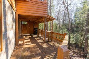 a wooden porch of a cabin in the woods at Hot Tub - Climber's Haven - Red River Gorge KY in Rogers +35 photos