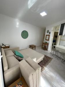 a living room with a couch and a table at Toninhas - Condomínio Wembley Tênis F201 in Ubatuba +24 photos