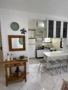 a kitchen with a table and chairs in a kitchen at Toninhas - Condomínio Wembley Tênis F201 in Ubatuba
