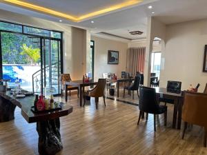 a dining room with tables and chairs and a large window at Viet Hoa Hotel & Residence Cat Ba - Rooftop Pool in Cat Ba