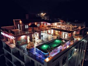an aerial view of a building with a swimming pool at night at Viet Hoa Hotel & Residence Cat Ba - Rooftop Pool in Cat Ba