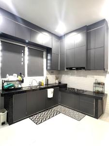 a kitchen with black cabinets and a sink at CFD HOMESTAY PB Dungun Private Pool in Dungun +1 photo