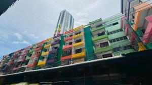 a building covered in colorful paint with a tall building at Bangkok-Pratunam Hotel in Ban Nong Chaeng