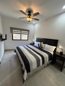 カボ・サン・ルーカスにあるBRAND NEW CONDO Cabo San Lucasのベッドルーム1室(ベッド1台、シーリングファン付)