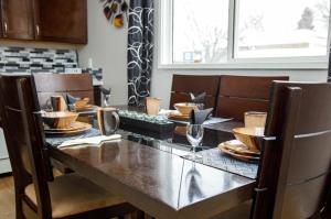 a dining room with a table and chairs with plates and wine glasses at 197 Le Maire Street in Winnipeg +4 photos