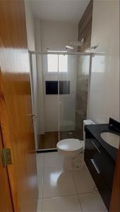 ein Badezimmer mit Toilette und Waschbecken in der Unterkunft Casa completa em Praia Grande, 500 metros da praia in Praia Grande