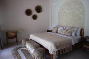 a bedroom with a bed and two chairs at Momy Breeze Uluwatu in Bingin Beach