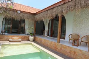 a villa with a swimming pool and a patio at Momy Breeze Uluwatu in Bingin Beach