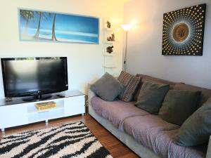 a living room with a couch and a flat screen tv at Marazul BEST DEAL - Stone Bathtub, WIFI, Functional - Mandarins and lemons when available in Vincentia