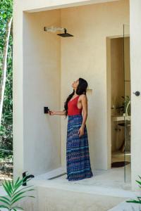 a woman in a dress holding a camera at Jungle Tiny Home Retreat - Casa de Seda in Chemuyil